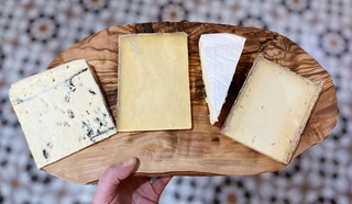 a cheeseboard with four cheeses on it